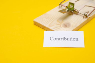 Üzerinde bir parça kağıt olan bir fare kapanı ve kopya alanı olan sarı bir zemin üzerindeki yazı. Borç kavramına göre,