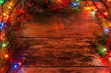 Güzel, sihirli Noel arkaplanı. Noel ağacı dalları, Noel çelenkleri, ahşap bir arka planda boncuklar, yer kopyalamak için bir yer.