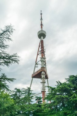 Mtatsminda Dağı 'ndaki Tiflis TV Kulesi bulutlu bir günde kapanıyor. Dikey fotoğraf