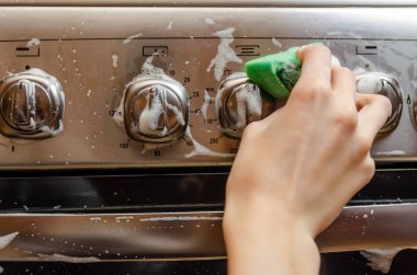 Kadının eli yeşil bir süngeri gri paslanmaz çelik gaz sobasının düğme kolunda köpükle yıkıyor. Daireyi temizliyorum.