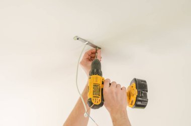 Tamirci, lambanın altına esneme tavanı için platform kurar