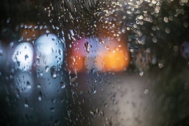 Yağmurlu günlerde, bulanık trafik ışığı, yağmurlu hava, yağmur ve bokeh ile yağmur pencereye düşer