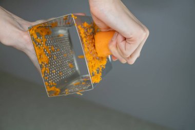 Kadın eli, ağız sulandırıcı, lezzetli havuç rendeleyici, ağırlık kaldırıcı, yakın çekim, aşağıdan yukarıya doğru fotoğraf.