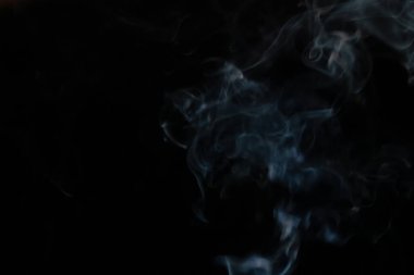Siyah arkaplanda kopyalama alanı olan soyut duman arkaplanı. Tütsü çubuğundan yükselen mavi-beyaz duman