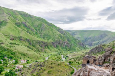 Mağara şehri Vardzia 'nın manzarası. Mağara şehrinden nehir vadisine ve güneşli bir yaz gününde yeşil yamaçlara bakın.