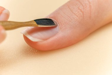 Kız kendi manikürünü yapıyor. Bir parmağın tırnak eti kesilmesi. Yakın plan.