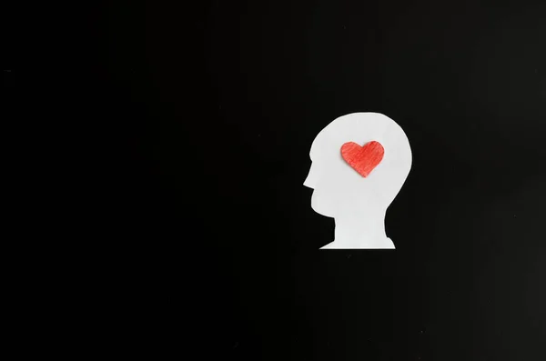 段ボールのテンプレートから黒い背景に男と彼の頭の上に心のイメージ 愛の心 — ストック写真