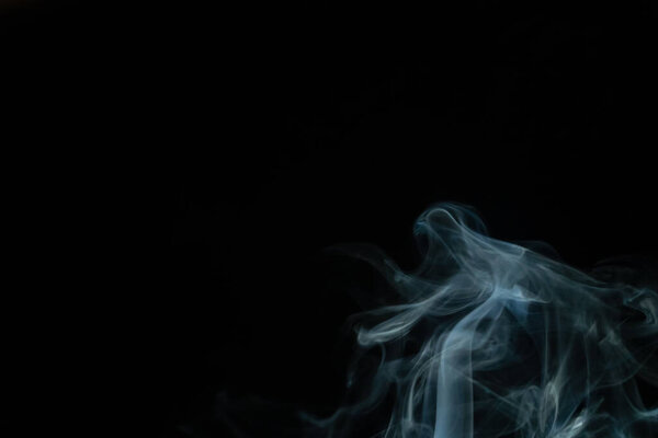 Beautiful abstract blue smoke with copy space on black background. Smoke background for art design or drawing. Abstract figure of the smoke