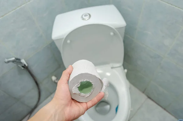 Mano Hombre Sostiene Rollo Papel Higiénico Blanco Sobre Inodoro Cerca — Foto de Stock