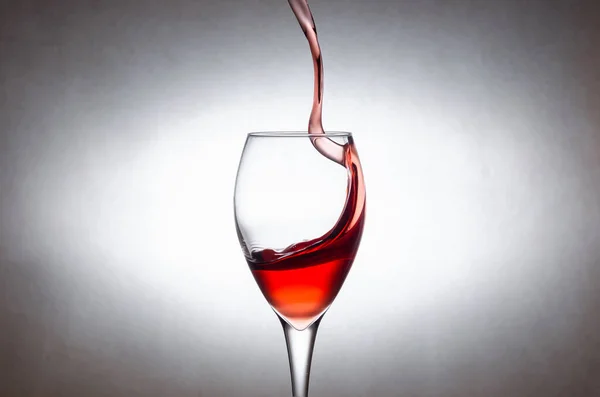glass of red wine on a white background. Freezing the movement of liquids in the photo.