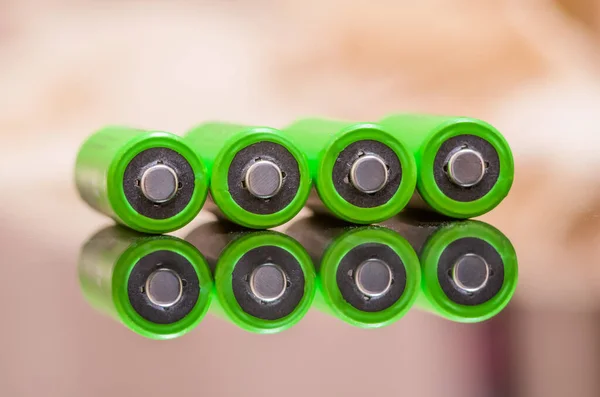 Close-up of green alkaline batteries. Close up colorful rows of AA batteries energy background selection of an abstract background of colorful batteries. Alkaline size battery. Battery reflection