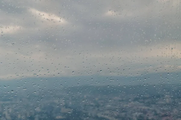 雨天時の観覧車のブースからトビリシの景色 街の背景にあるガラスの上に落ちる — ストック写真