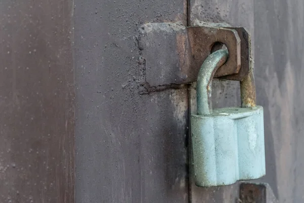 Karanlık bir demir duvarda büyük gri ahır kilidi, kapı. Çok doğal. Kapalı kapı. Eski metal kilit