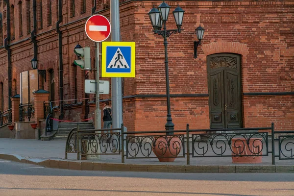 City street, road signs: pedestrian crossing sign and brick sign