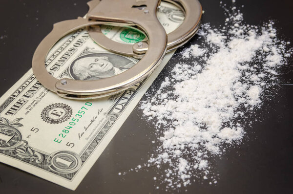Handcuffs, money and cocaine drugs on black background close up