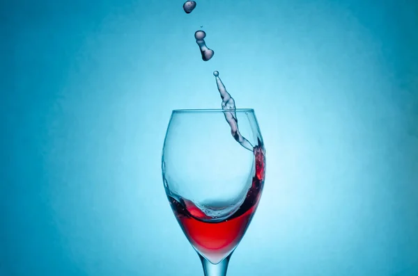Όμορφες Πιτσιλιές Σταγόνες Κόκκινου Κρασιού Ένα Ποτήρι Μπλε Φόντο Κοντινό — Φωτογραφία Αρχείου
