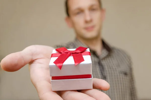 Uomo Dai Capelli Scuri Con Sorriso Tende Una Scatola Regalo — Foto Stock