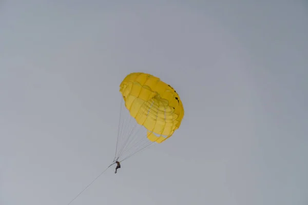 Желтым Парашютом Парашютиста Летящего Воздуху Фоне Светло Фиолетового Неба — стоковое фото