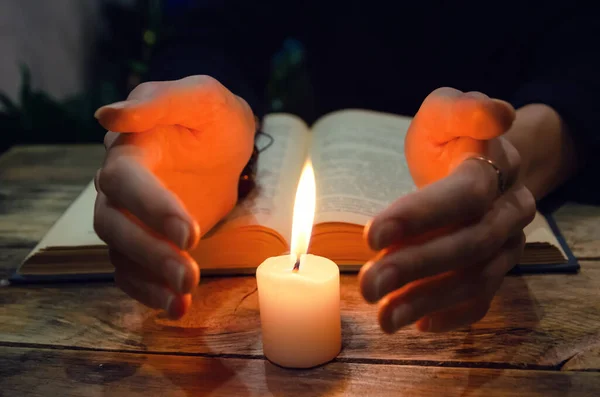 Χέρια Κοντά Στο Κερί Και Ένα Βιβλίο Στο Τραπέζι Έννοια — Φωτογραφία Αρχείου