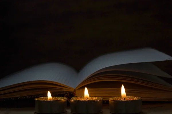 Encender Velas Cerca Del Libro Viejo —  Fotos de Stock