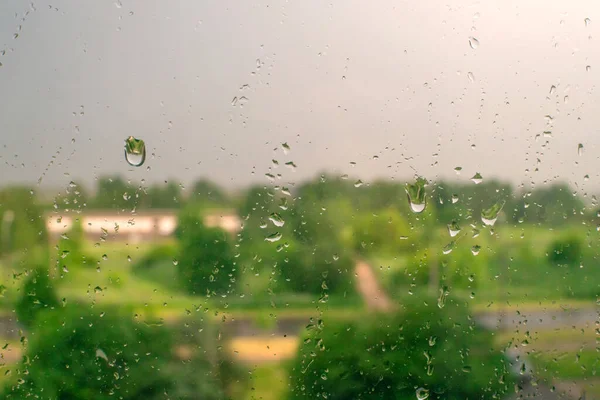 Dešťové Kapky Okně Zelenými Stromy Zamračenou Oblohou Pozadí Letní Den — Stock fotografie