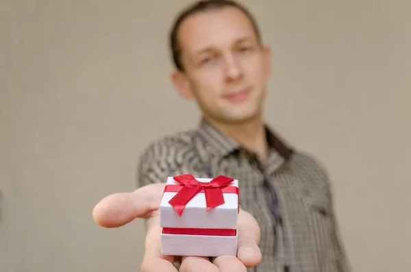 Uomo Dai Capelli Scuri Con Sorriso Tende Una Scatola Regalo — Foto Stock