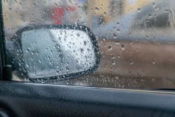 背景に鏡を持つ車の窓に雨が降ります 車の右側のミラー — ストック写真