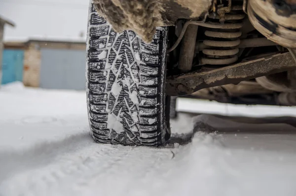 The car tire in the snow close up. Car tracks on the snow. Traces of the car in the snow. Winter tires. Tyres covered with snow at winter road — Stock Image Car Tire Snow Close Car Tracks Snow Traces Car Snow Stock Image