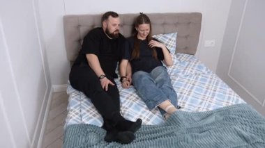 Authentic moments of a couple lying on their bed, engaged in conversation, showcasing the dynamics of their relationship and the importance of communication in a comfortable setting