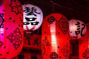 Fenerler bir evin önüne asılmış. Geleneksel Çince şablonlar ve sözcükler onun üzerinde çalışma sanatı anlamına geliyor..