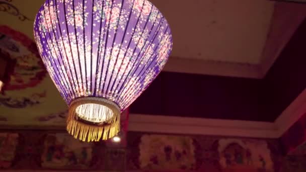 一种拱形相机 它是用紫色灯笼拍摄的 花纹挂在寺庙的屋顶上 灯笼在夜晚散发出温暖的感觉 — 图库视频影像