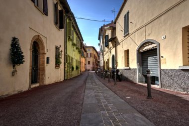 Rimini, İtalya - 20 Ekim 2019: Park etmiş motosiklet, scooter ve bisikletli sessiz arka sokak.