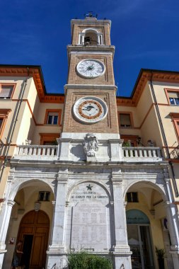 Rimini, İtalya - 20 Ekim 2019: Saat, takvim ve savaş anıtı bulunan kilise kulesi Piazza Tre Martiri 'de (Üç Şehit Meydanı)