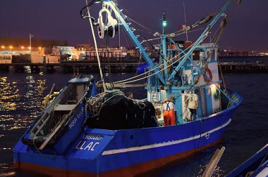 Chimbote, Peru - 17 Nisan 2018: Küçük teknelerdeki adamlar balıkçı teknelerinde balıkçılık yapmak için gece balıkçılığına hazırlanıyorlar.