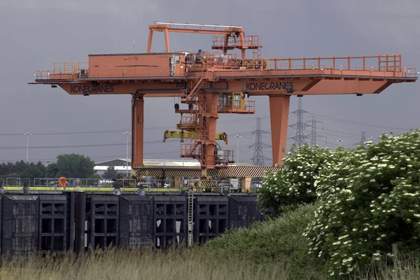 Thames Nehri, Birleşik Krallık - 27 Mayıs 2017: Gantry Crane konteynırı römorkörle çekilen mavnalarla nehirdeki iskeleye yüklüyor