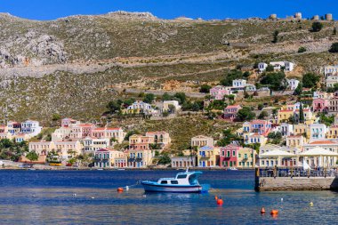 Harika Yunanistan. Renkli binalar ve mavi deniz manzaralı Symi adasının kıyı şeridi, Yunanistan