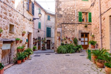 Mallorca Adası, Balearic Adaları, İspanya - 4 Ocak 2019: Valldemossa eski kasabasında çiçeklerle süslenmiş taş binalarla dolu güzel bir cadde