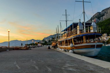 Baska Voda, Hırvatistan - 12 Eylül 2018: Denizde güzel bir gün batımı. Gün batımında Adriyatik Denizi kıyısında gezinti. Dalmaçya 'nın Baka Voda adlı turizm köyü