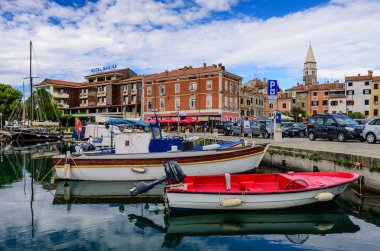 Izola, Slovenya - 20 Eylül 2016: Izola 'da deniz kıyısında tekneleri ve parlak renkli evleri olan manzaralı liman. Slovenya 'yı gezmek, popüler turizm beldesi