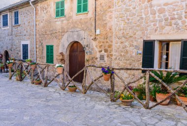 Mallorca Adası, Balearic Adaları, İspanya - 4 Ocak 2019: Valldemossa eski kasabasında çiçeklerle süslenmiş taş binalarla dolu güzel bir cadde