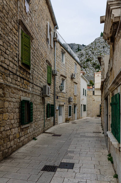 Omis town, Dalmatia region, Croatia - September 13, 2018: Omis old town. Traditional narrow street with stone houses