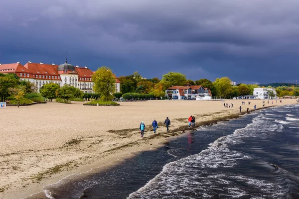Sopot, Polonya - 6 Ekim 2019: Fırtınalı gökyüzü ile Sopot kasabasındaki Baltık deniz kıyıları. İnsanlarla dolu kumsal