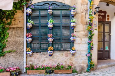 Mallorca Adası, Balearic Adaları, İspanya - 4 Ocak 2019: Çiçek saksılarıyla süslenmiş duvar. Valldemossa, eski kasaba. Mallorca adasındaki popüler turizm beldesi