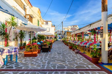 Samos Adası, Yunanistan - 24 Mayıs 2017: Kokkari köyünde açık hava restoranları olan renkli bir cadde. Kokkari köyü Samos adasında popüler bir turistik yerdir..