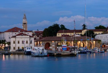 Koper, Slovenya - 17 Eylül 2016: Tekneler ve eski binalarla Koper gezinti alanının güzel bir akşam manzarası