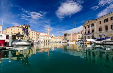 Piran, Slovenya - 19 Eylül 2016: Limanda güzel eski binaları ve tekneleri olan Piran şehri manzarası. Piran, Slovenya 'nın başlıca turistik merkezlerinden biri.