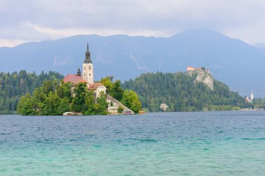 Küçük adadaki St. Marys Varsayım Kilisesi ile kan gölü. Kan, Slovenya, Avrupa. Arka planda dağlar ve vadiler. 
