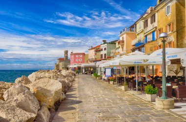 Piran, Slovenya - 19 Eylül 2016: Piran 'ın tarihi merkezinde parlak renkli binalar bulunan Manzaralı Rıhtım. Piran, Slovenya 'nın başlıca turistik merkezlerinden biri.