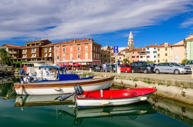 Izola, Slovenya - 20 Eylül 2016: Izola rıhtımında tekneleri ve parlak renkli evleri olan manzaralı liman.