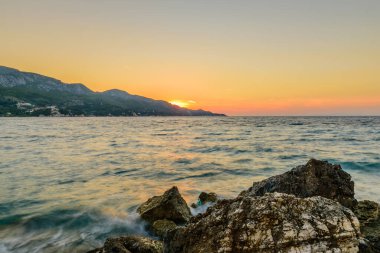 Denizde güzel bir gün batımı. Yunanistan 'ın Samos adasındaki Kokkari köyündeki pitoresk plaj..